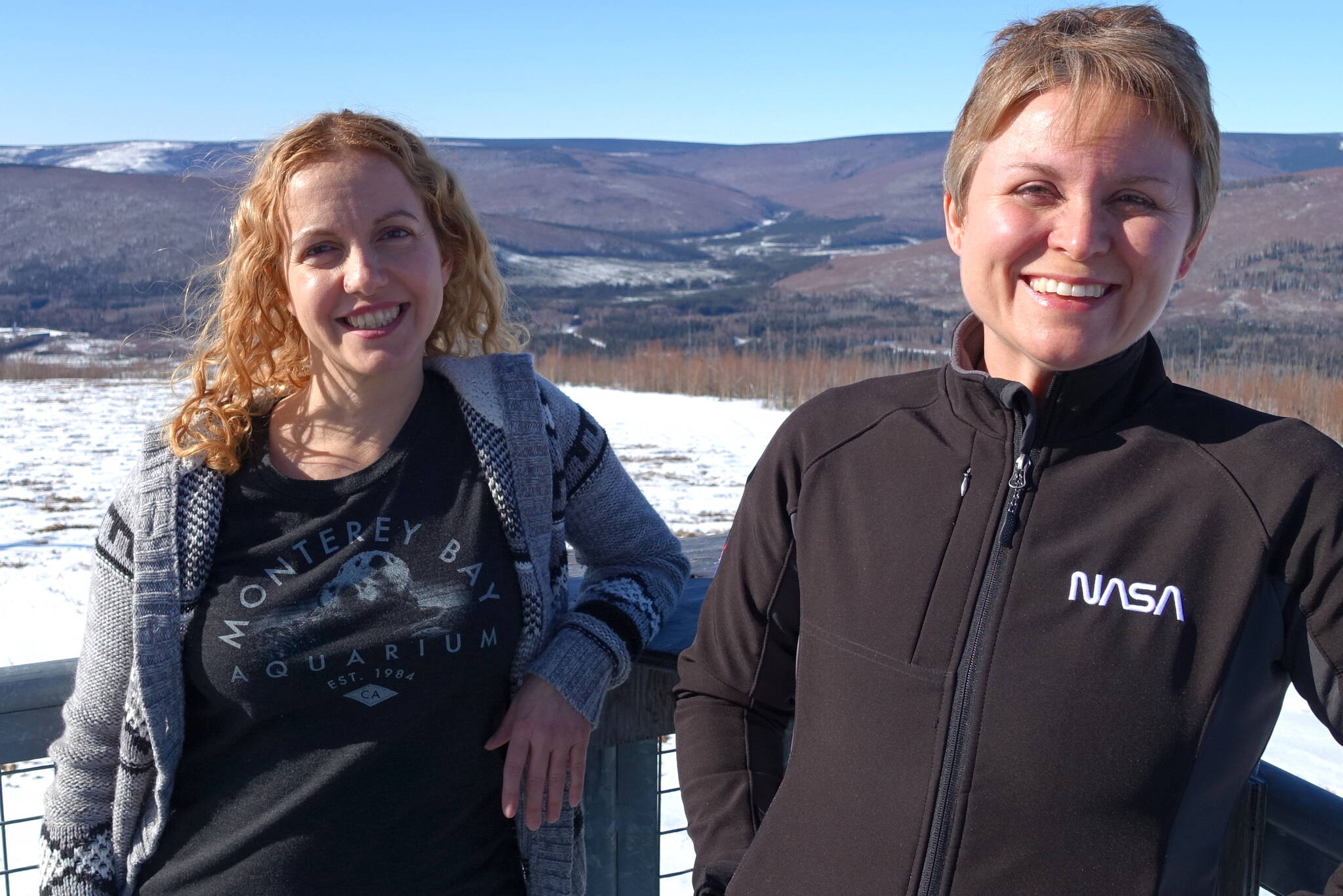 Astrophysicists Lindsay Glesener, left, and Sabrina Savage enjoy the sunshine on an observation deck at the Neil Davis Science Center on a hilltop at Poker Flat Research Range north of Fairbanks. (Photo by Ned Rozell)