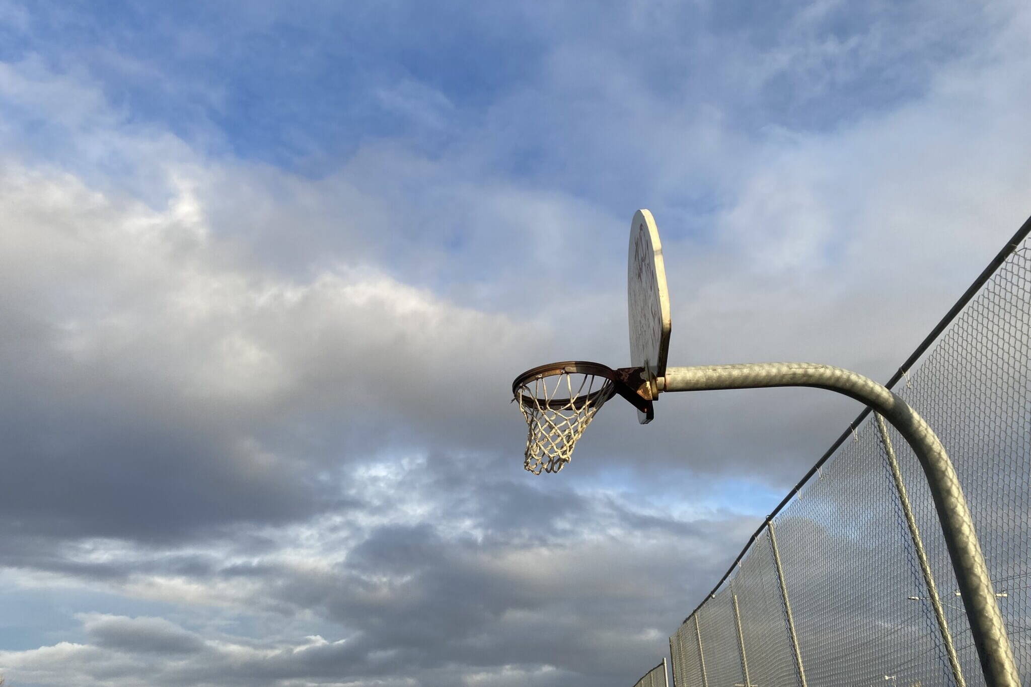An outdoor basketball hoop is seen in Bethel in October 2022. Alaskans will be able to play only on sports teams that match their gender at birth through college if a new bill becomes law. (Photo by Claire Stremple)