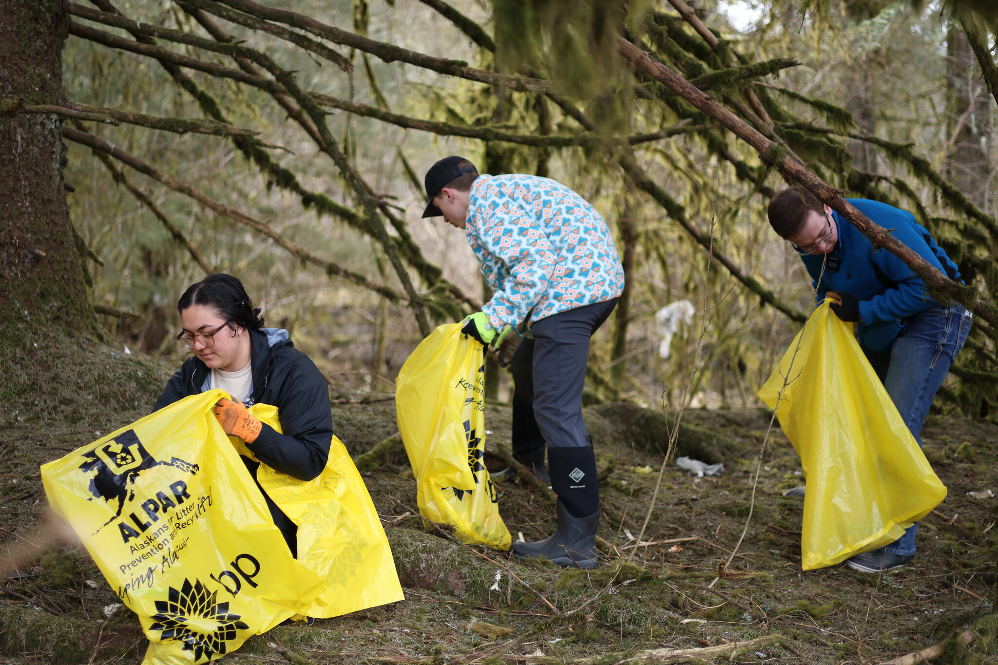 Sister Sadria Akina, Elder Tanner Christensen and Elder Bronson Forsberg, all missionaries with the Church of Jesus Christ of Latter Day Saints, collect litter on April 22, 2023, in the Lemon Creek area. It was their first time partaking in Juneau’s communitywide cleanup. (Ben Hohenstatt / Juneau Empire file photo)