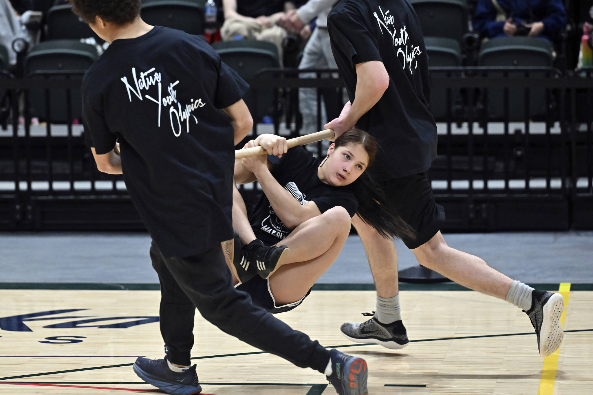 Eulalia Roman, 12, with team Mat-Su competes in the wrist carry on the first day of the Native Youth Olympics Senior Games at the Alaska Airlines Center on Thursday in Anchorage. (Bill Roth/Anchorage Daily News via AP)