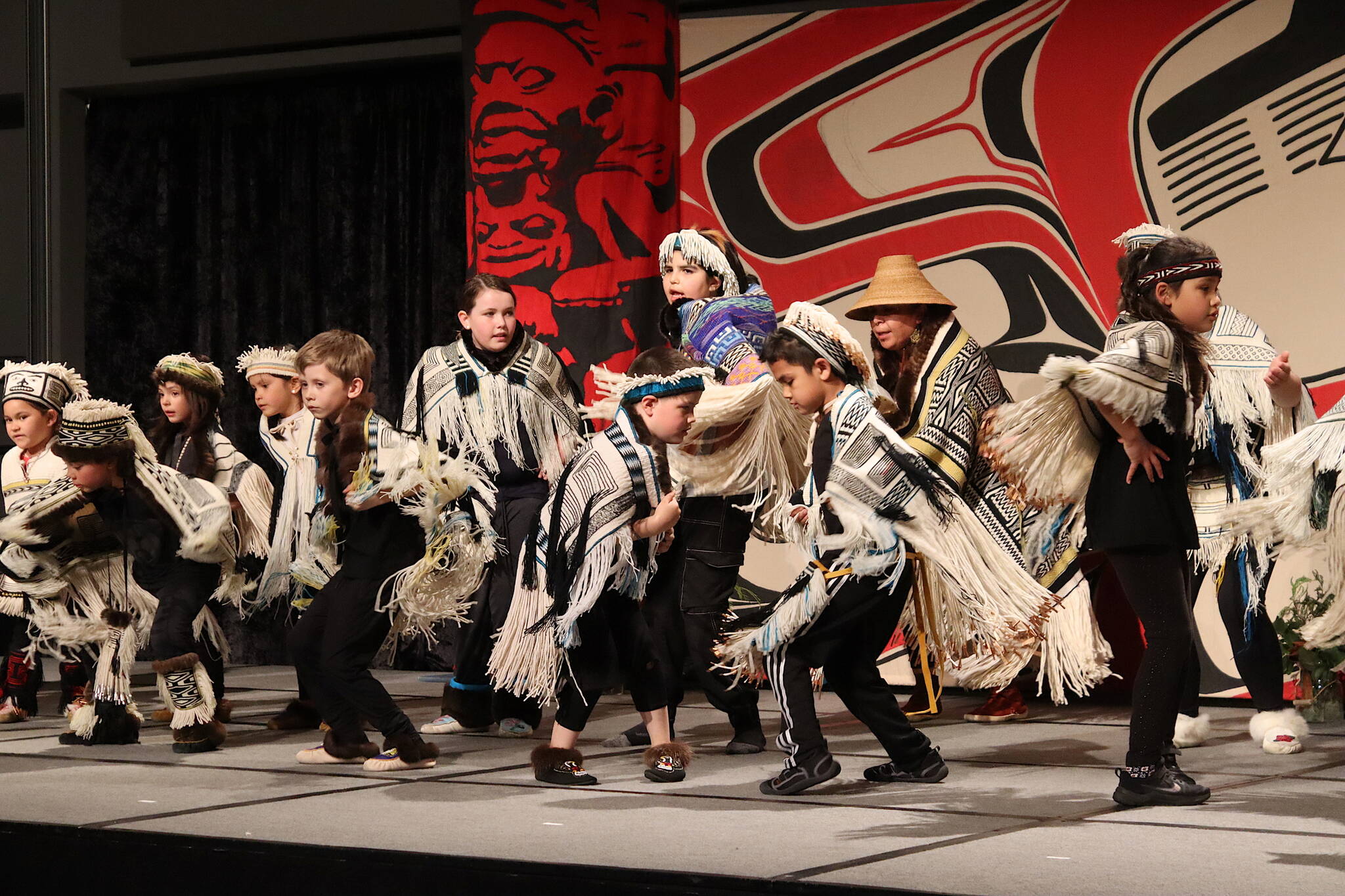 About 20 youths dance in Ravenstail robes during a ceremony at Centennial Hall on Tuesday evening featuring the history of the ceremonial regalia. (Mark Sabbatini / Juneau Empire)