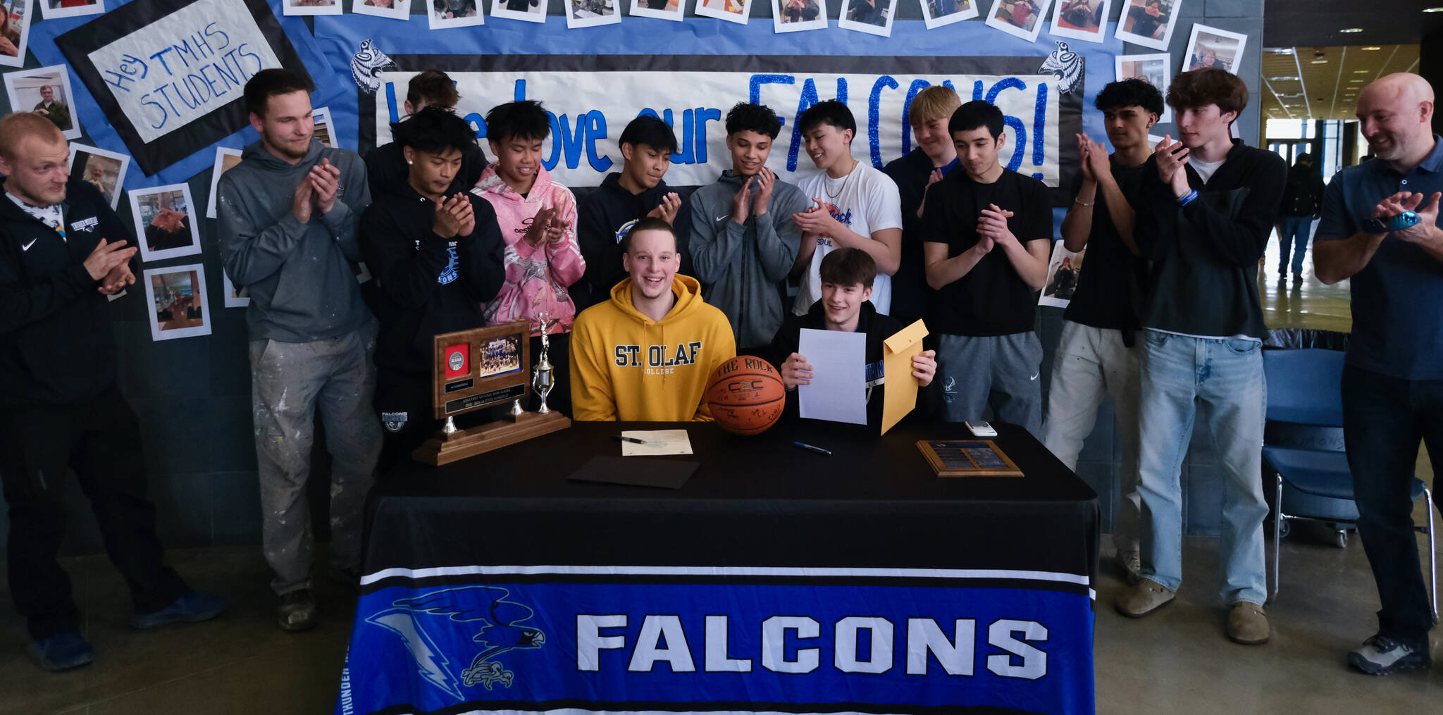 James Polasky, left, and Samuel Lockhart, right, pose with their families after signing letters of intent on Thursday in the TMHS commons to play college basketball. Polasky will attend St. Olaf in Minnesota and Lockhart will attend Edmonds College in Washington state. (Klas Stolpe / For the Juneau Empire)