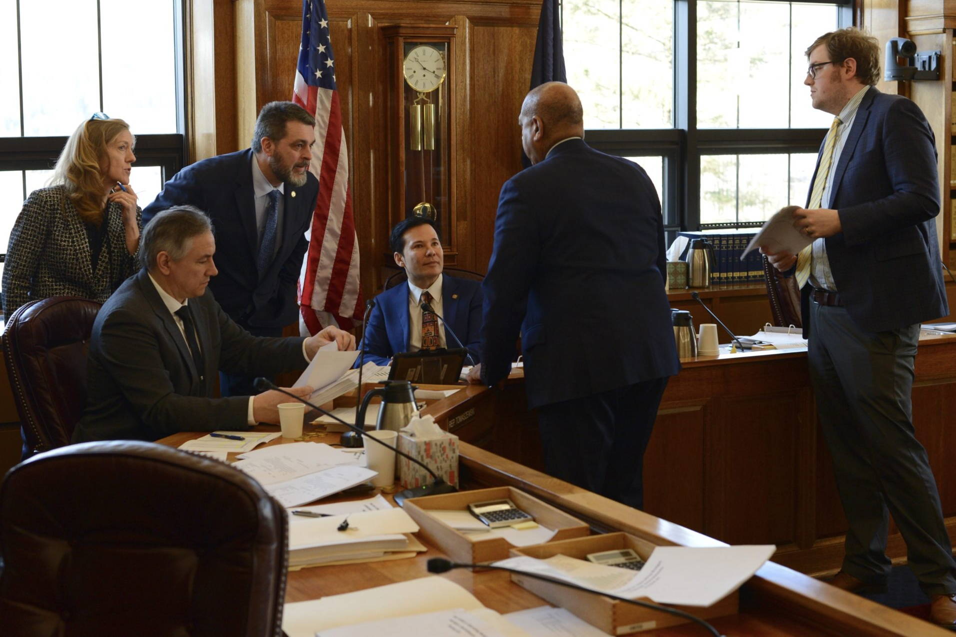 Members of the Alaska House Finance Committee, at left, listen to budget aide Remond Henderson during a break in amendment discussions on Monday, March 27, 2023. (James Brooks/Alaska Beacon)