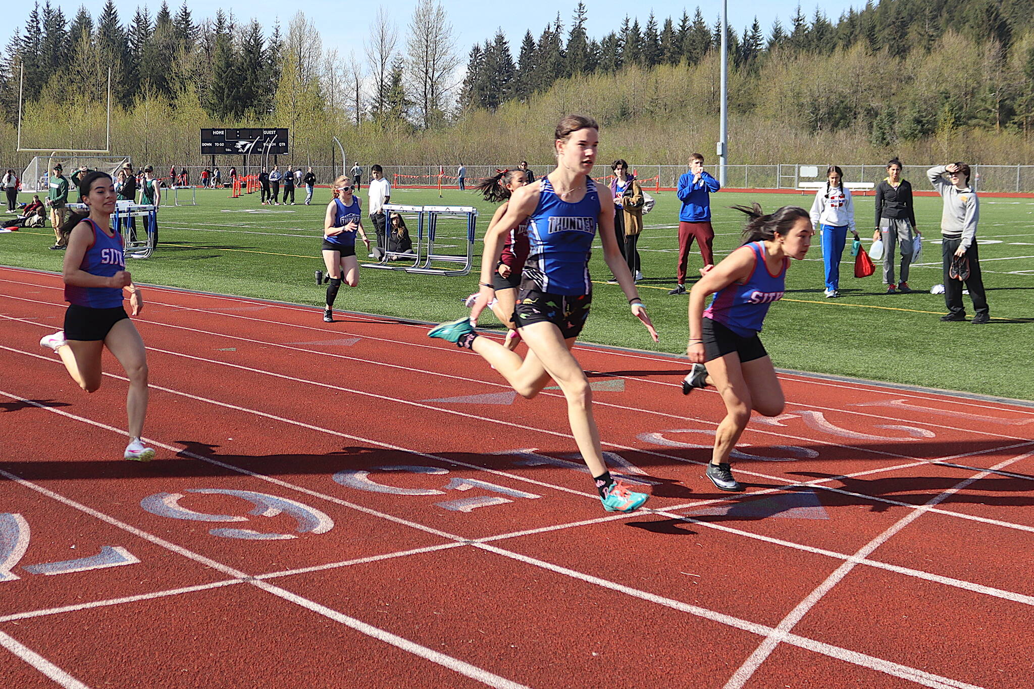 A photo finish in the 100-meter dash sees Sitka High School’s Adalyna Moore (right) finish ahead of Thunder Mountain High School’s Kerra Baxter — although both were officially clocked at 13.54 seconds — during the Capital Invitational Track and Field Meet on Saturday at TMHS. (Mark Sabbatini / Juneau Empire)