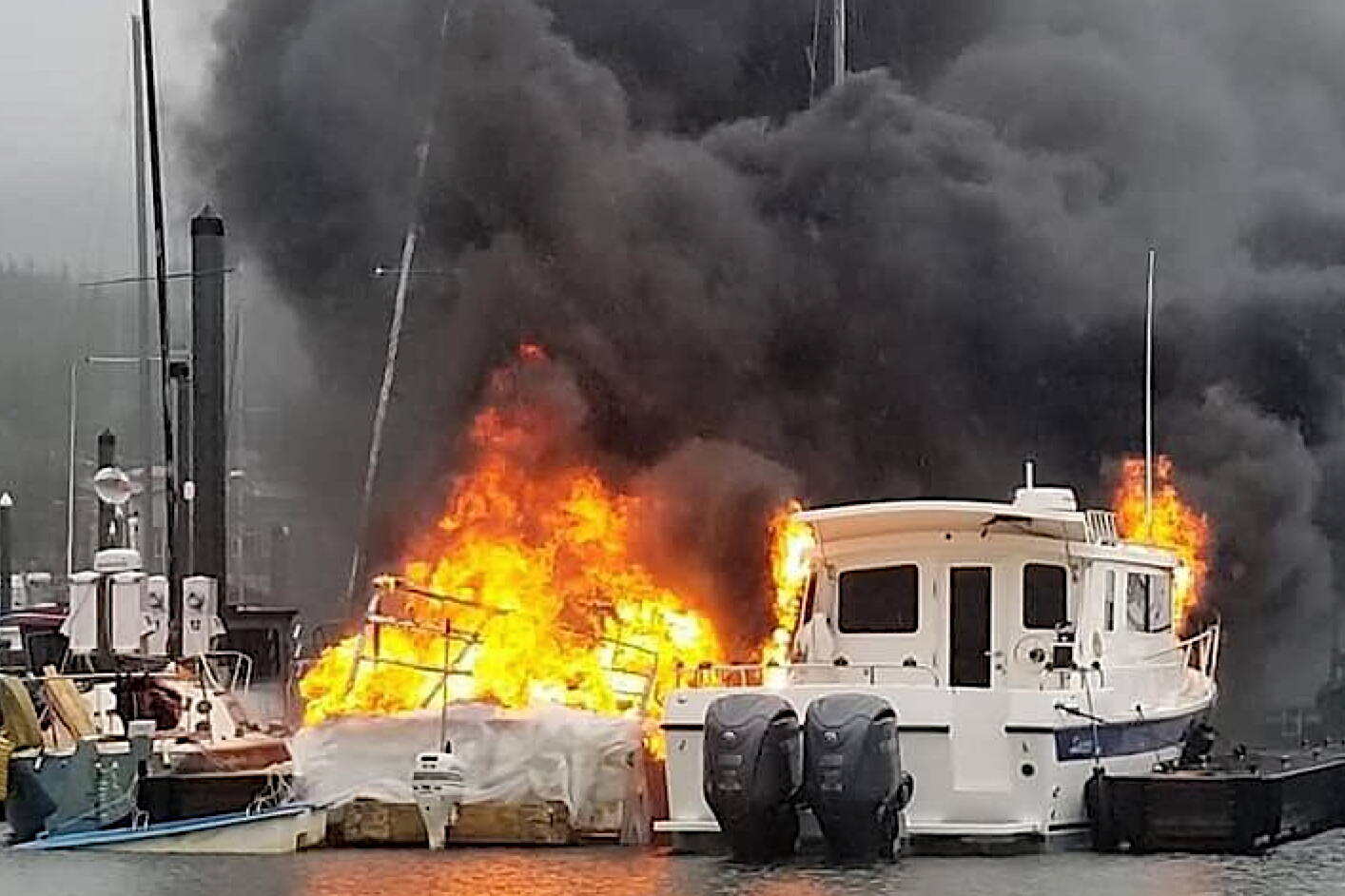 A boat is fully engulfed by fire in Douglas Harbor on Monday evening, with the fire spreading to two other boats. (Capital City Fire/Rescue photo)