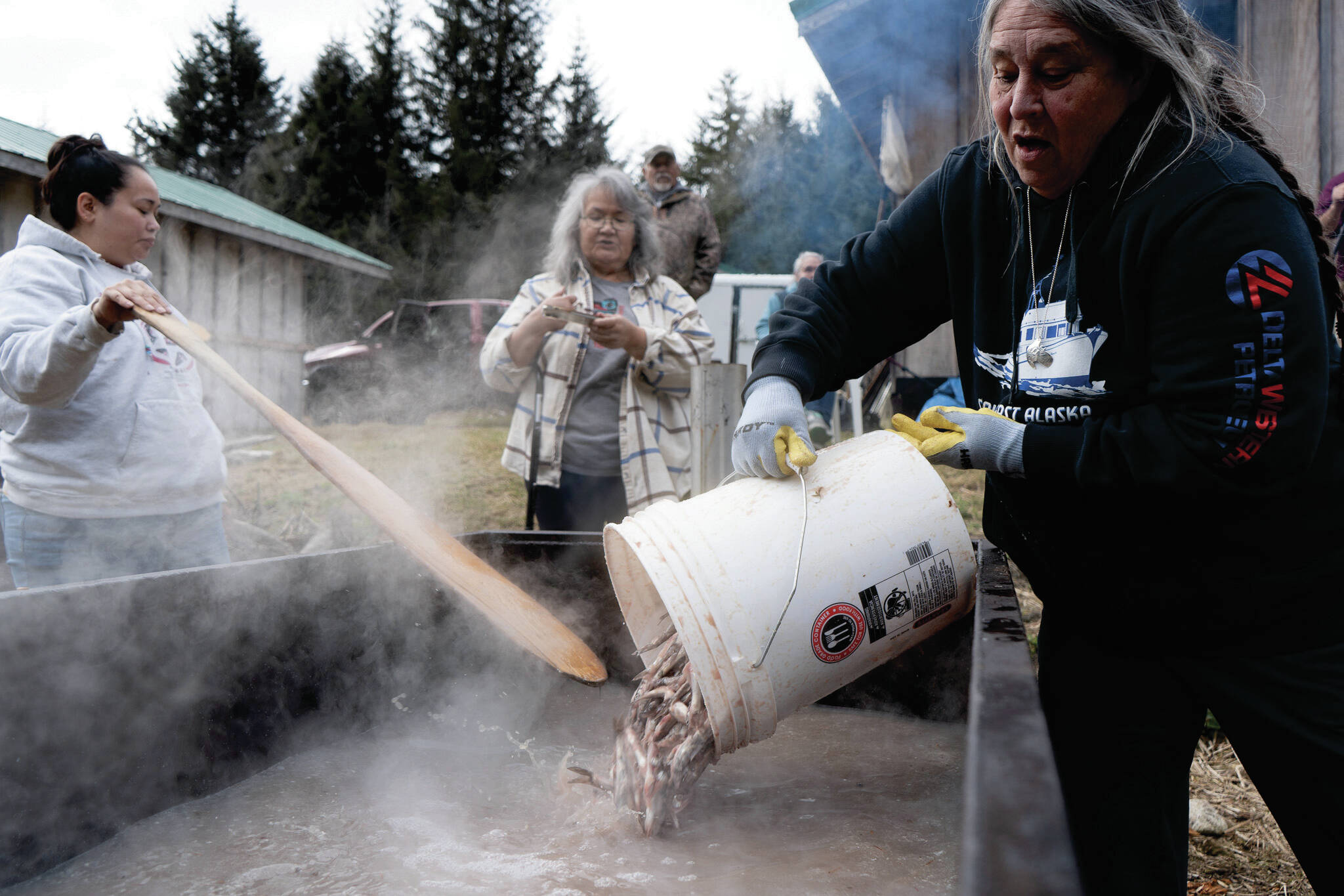 Dori Thompson pours hooligan into a heating tank on May 2. (Lex Treinen/Chilkat Valley News)