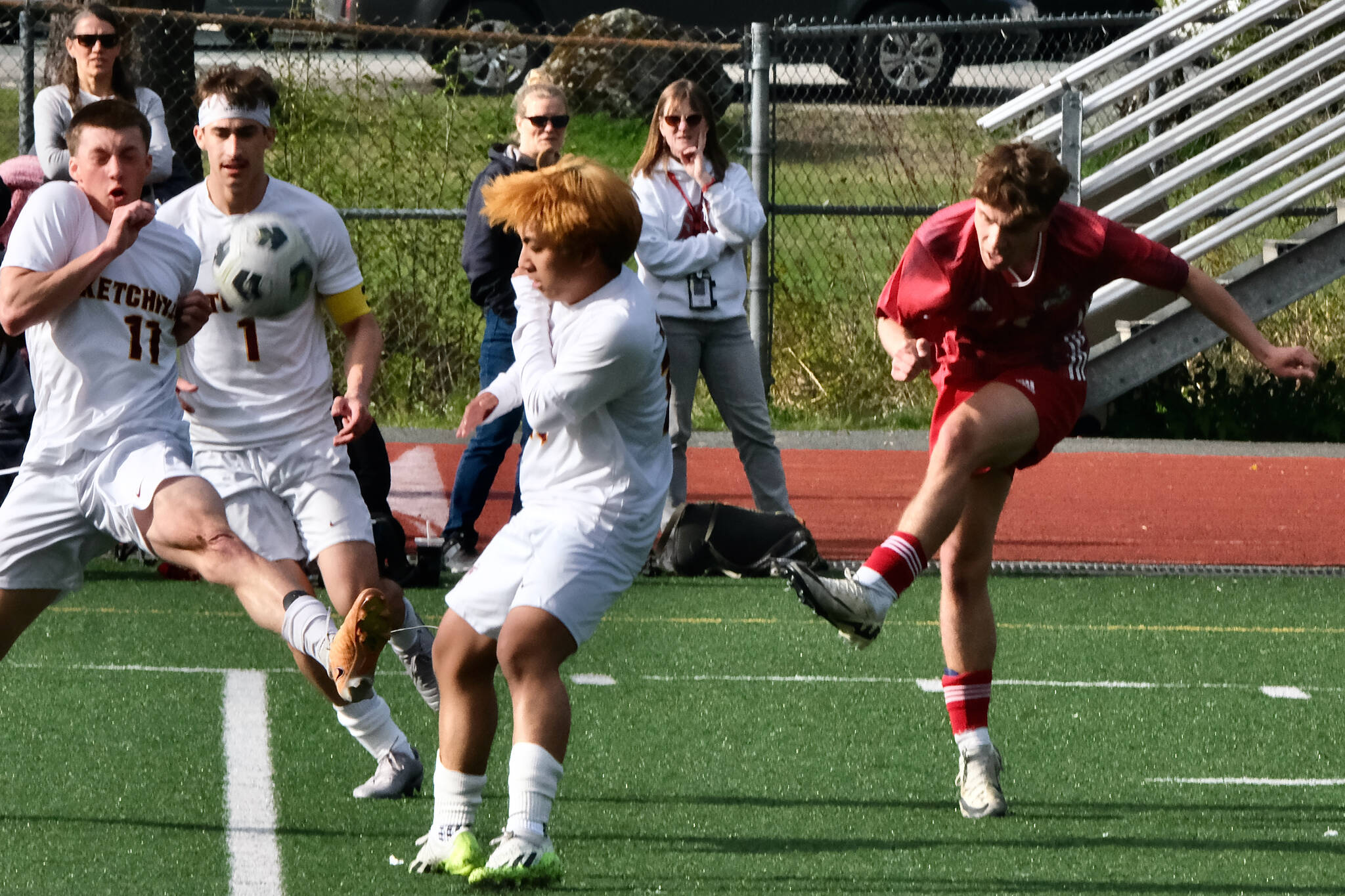 Juneau-Douglas High School: Yadaa.at Kalé junior Kai Ciambor puts a shot past Ketchikan’s Kingston Dell (11), Alex Gilley (1) and Eunchong Lee during the Crimson Bears 4-2 win over the Kings at Adair-Kennedy Field on Friday. (Klas Stolpe / For the Juneau Empire)