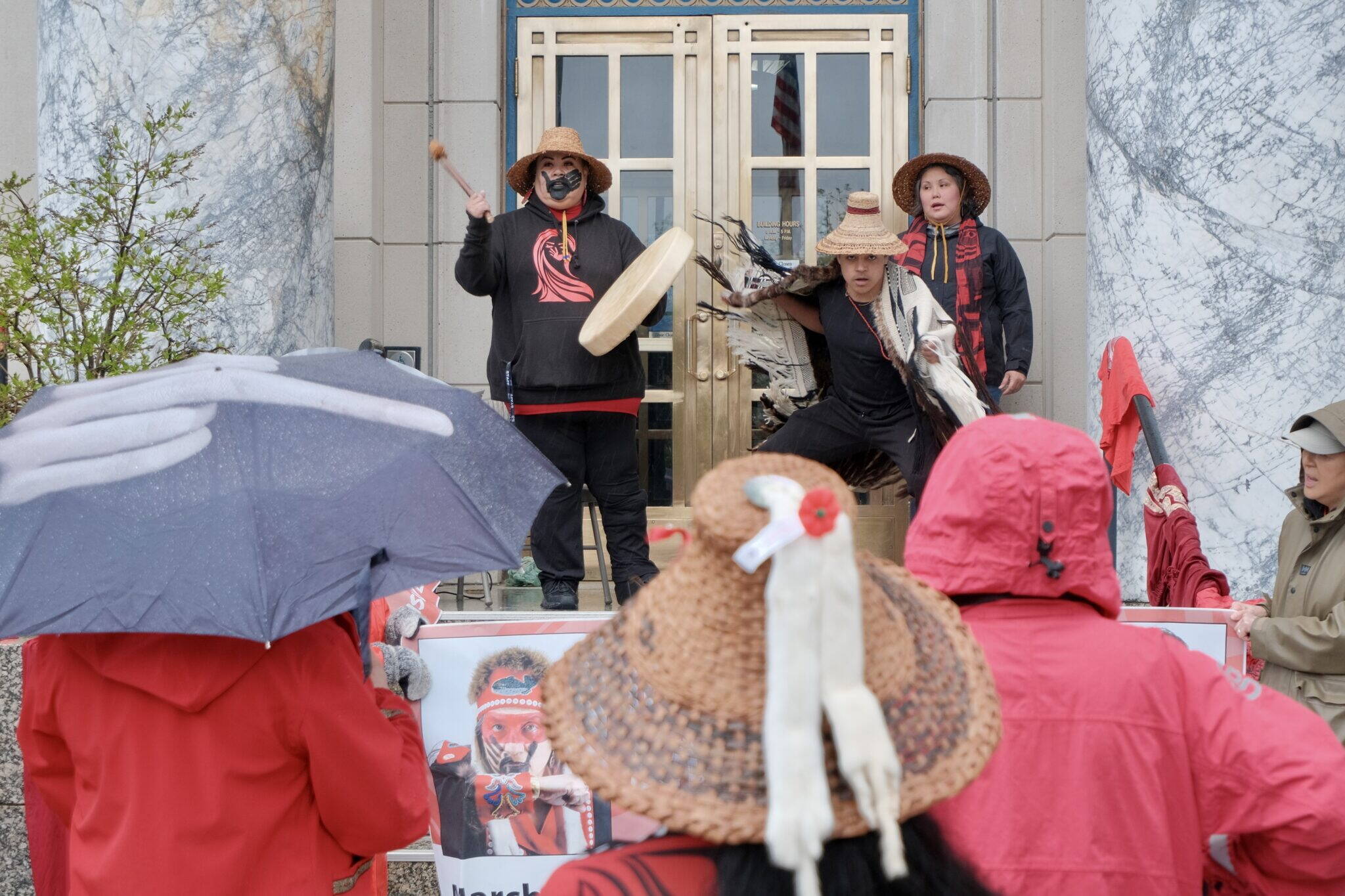 Jennifer Brown plays the drum while Jarrell Williams dances at an MMIP rally on the Alaska State Capitol steps on May 5. (Claire Stremple/Alaska Beacon)