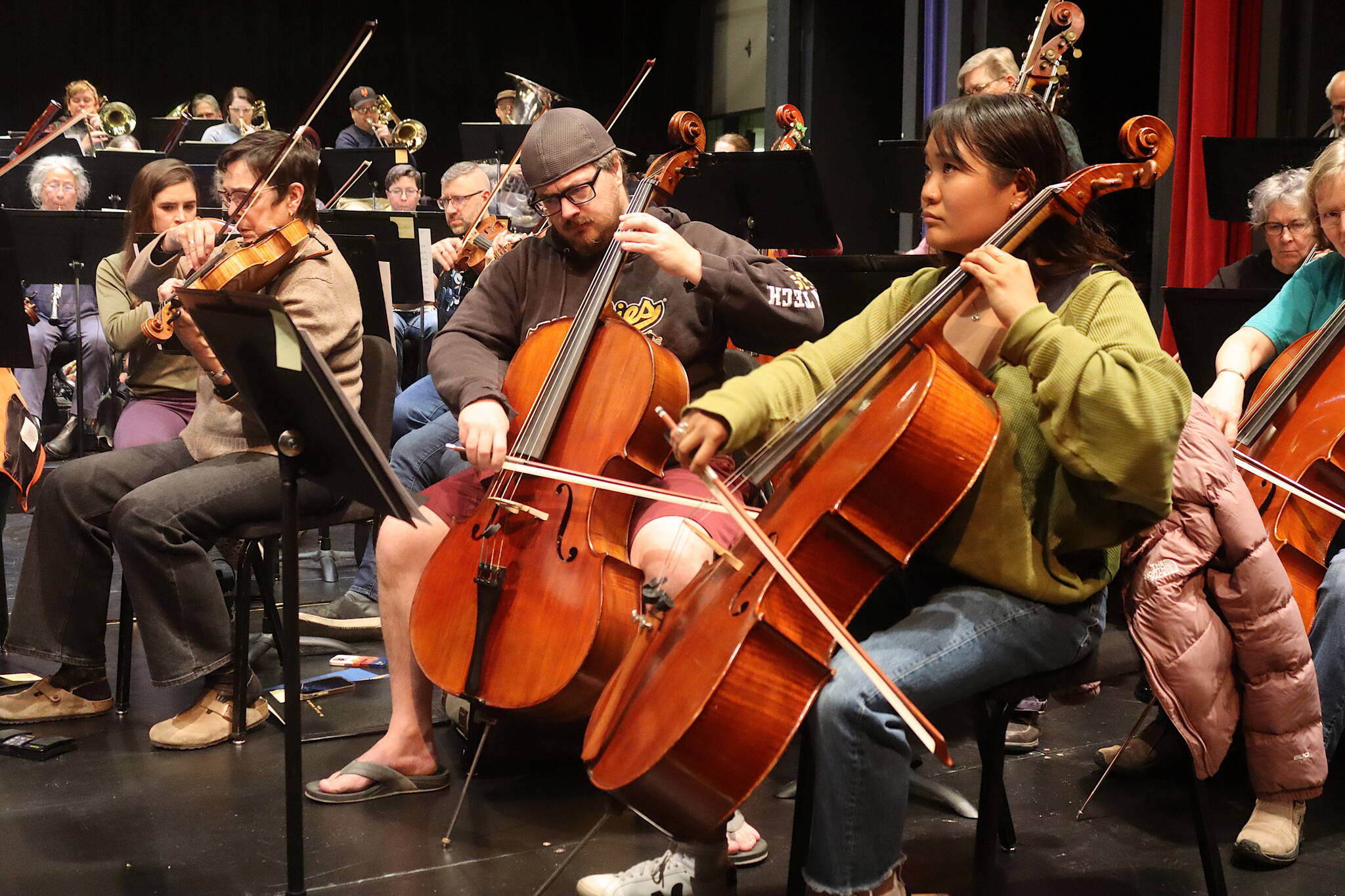 Juneau Symphony members rehearse Thursday for this weekend’s “BOOM” pops concerts at the Juneau-Douglas High School: Yadaa.at Kalé Auditorium. (Mark Sabbatini / Juneau Empire)