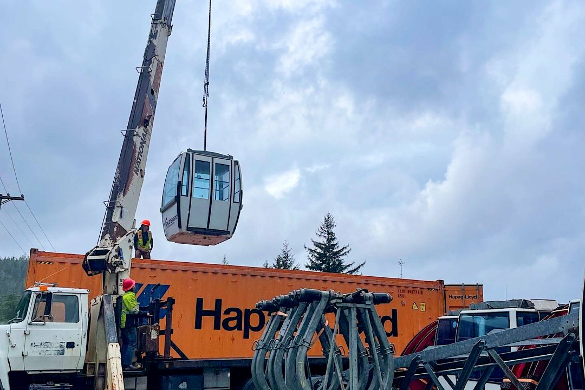 A crane unloads a car from a used gondola after its arrival in Juneau in 2022. Eaglecrest Ski Area officials say they are hoping the gondola will be operational by the 2025-26 winter ski season. (Photo courtesy of Eaglecrest Ski Area)
