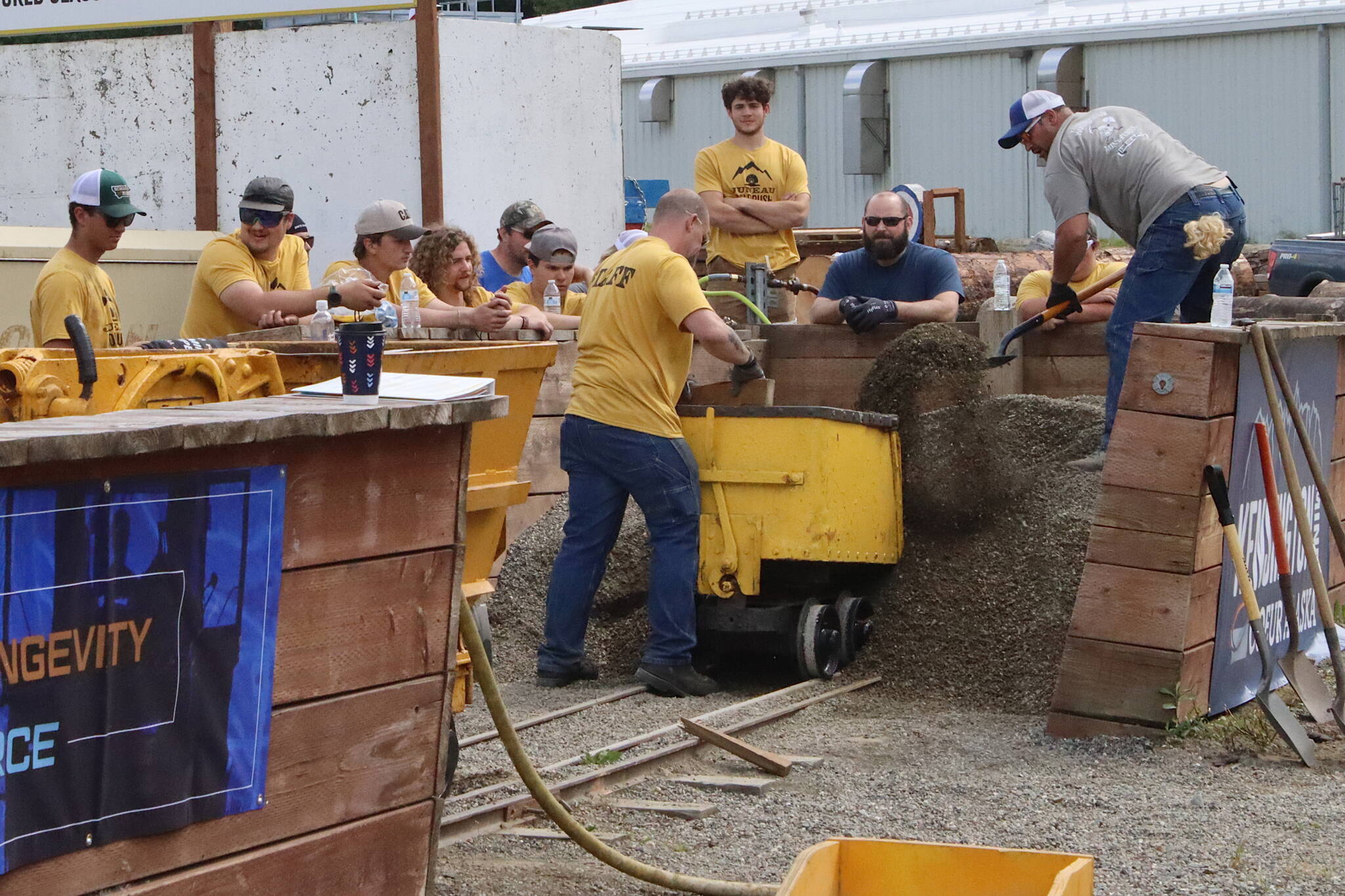 Eddie Petrie shovels gravel into a mine cart as fast as possible during the mens hand mucking competition as part of Juneau Gold Rush Days on Saturday at Savikko Park. (Mark Sabbatini / Juneau Empire)