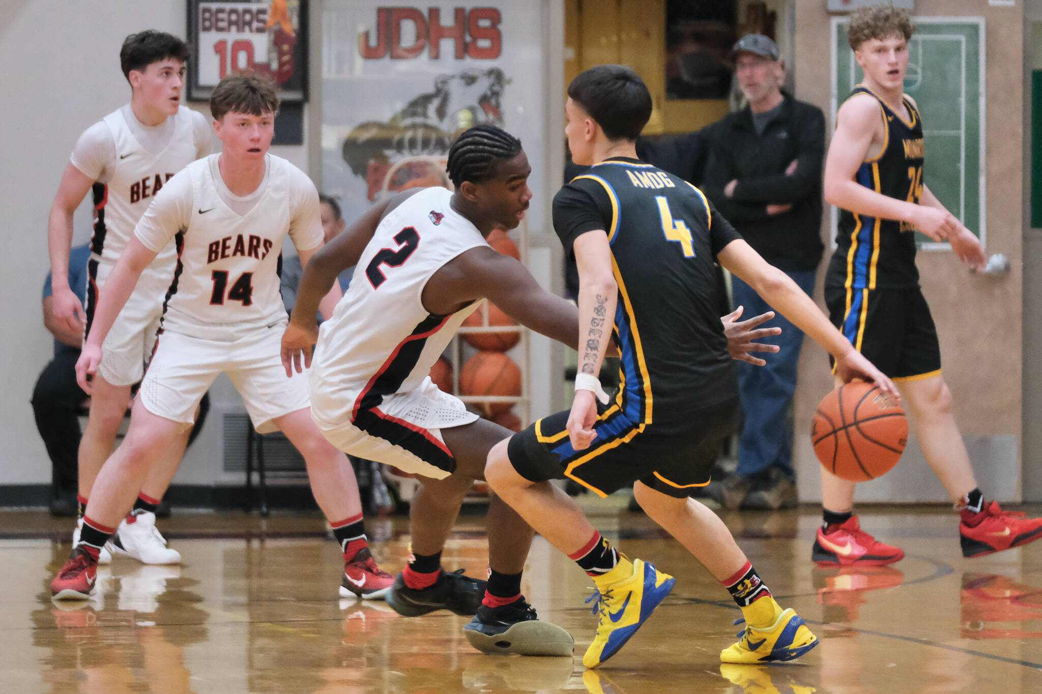 Juneau-Douglas High School: Yadaa.at Kalé senior Ahmir Parker (2) attempts a steal as Monroe senior Jett McCullough (4) dribbles behind his back during the Crimson Bears 71-55 loss to the Rams on Saturday in the George Houston Gymnasium. (Klas Stolpe / Juneau Empire)