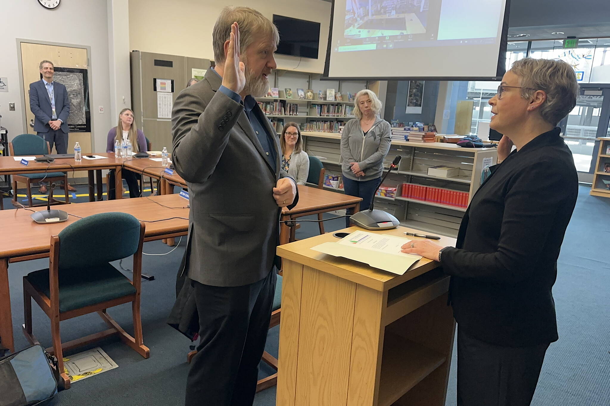 Steve Whitney (left) is sworn in as a Juneau Board of Education member by Superior Court Judge Amy Mead in the library at Thunder Mountain Middle School on Saturday, May 17, 2025, after five candidates were interviewed by the other board members to fill the seat vacated when Will Muldoon resigned last month. (Mark Sabbatini / Juneau Empire)