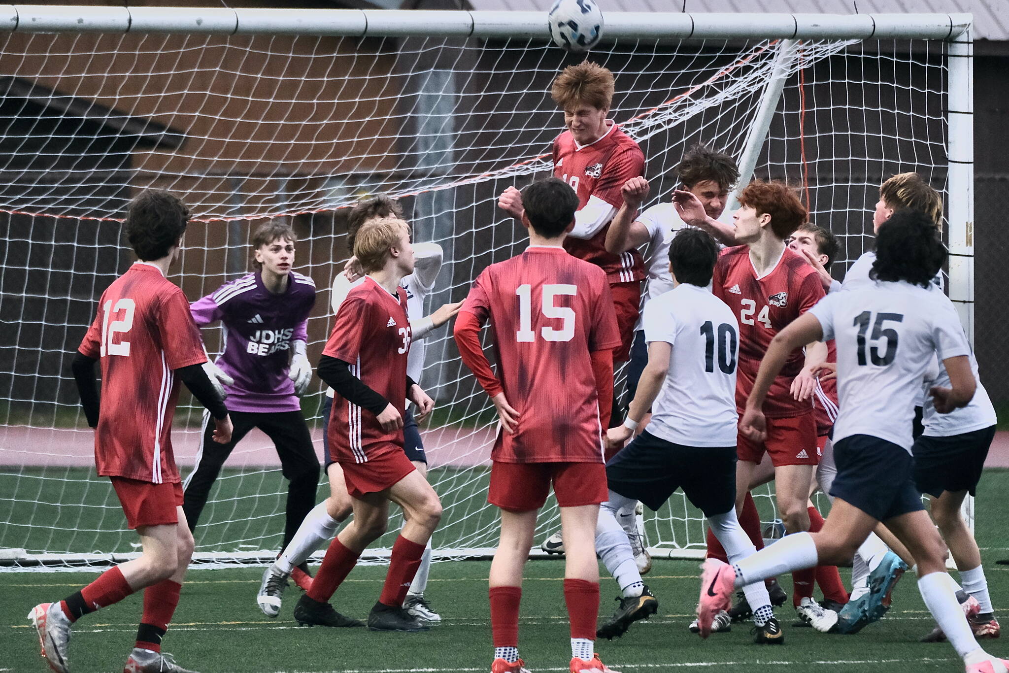 In this file photo from last weeks home win against Soldotna the Juneau-Douglas High School: Yadaa.at Kalé back defense of Ryan Thibodeau (12), keeper Callen Walker, Elliott Welch (35), Bryce Haygood (15), Reed Maier (19) heading the ball, Erik Thompson (24) and Owen Rumsey defend the box in a win over the Stars. (Klas Stolpe / Juneau Empire file photo)