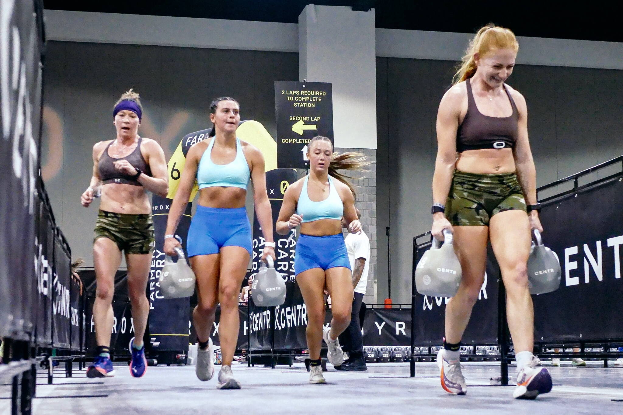 Chrish Newell, right, and partner Jess Contreras, far left, compete in the Farmers Carry during the HYROX 2025 Atlanta Doubles in late April. They qualified for the World Championships scheduled Sunday, June 15, 2025, in Chicago. (Photo courtesy Chris Newell)