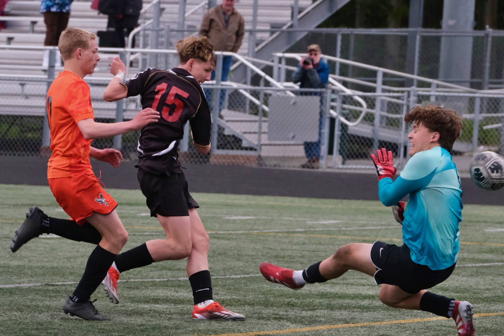 Juneau-Douglas High School: Yadaa.at Kalé freshman Bryce Haygood scores past West Anchorage sophomore defender Nathan Conlon and sophomore keeper Gideon Plikat during the Crimson Bears 3-2 loss in extra time to the Eagles in the 2025 ASAA/First National Bank Alaska Soccer State Championship semifinals Friday at Wasilla High School. (Klas Stolpe / Juneau Empire)