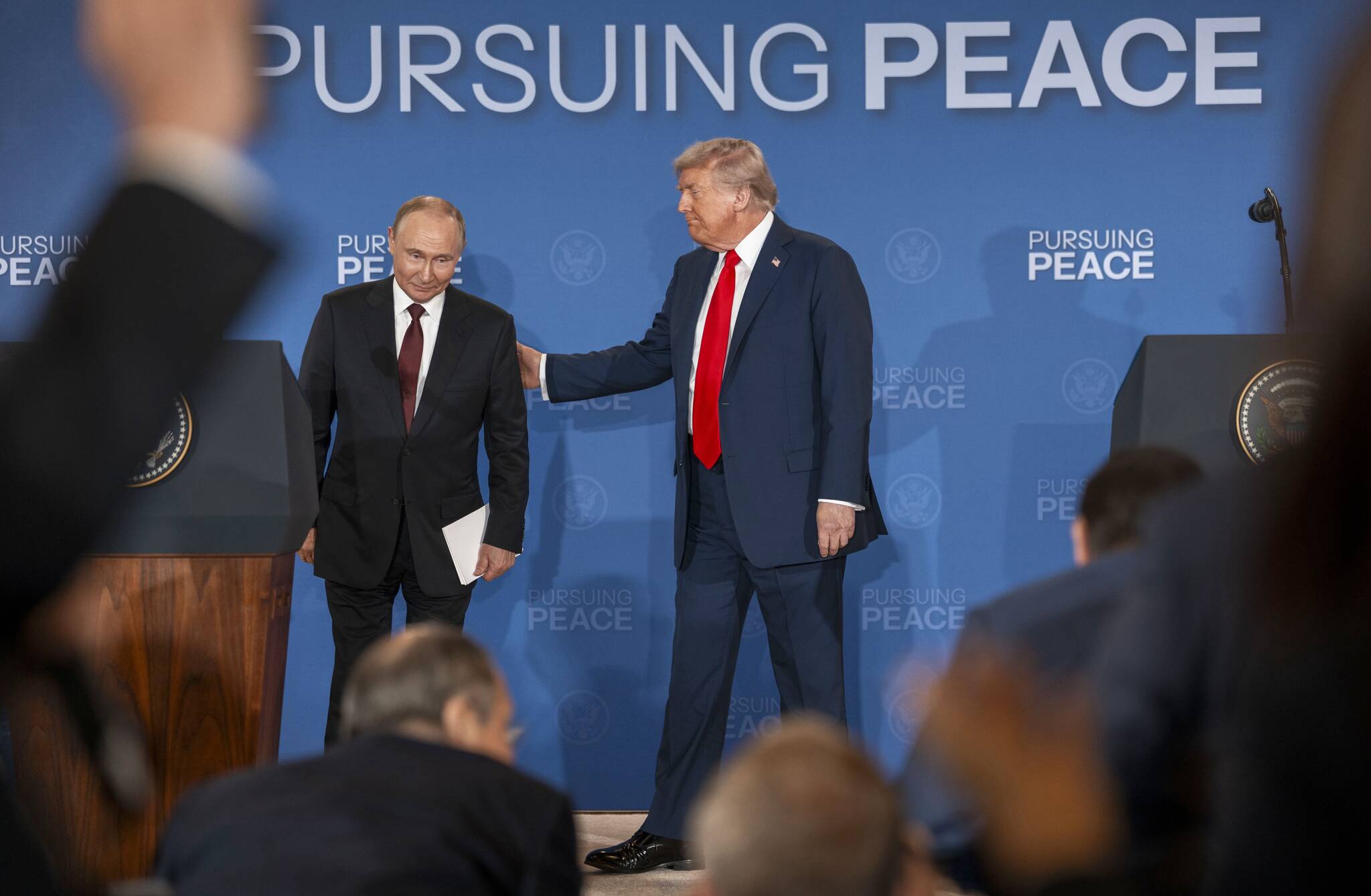 Russian President Vladimir Putin and President Donald Trump begin to leave the stage after making statements following their meeting in Anchorage, Alaska, Aug. 15, 2025. After that meeting, Trump adopted Putin’s preference for pursuing a sweeping peace agreement that would require Ukraine to cede territory to Russia. (Doug Mills/The New York Times)