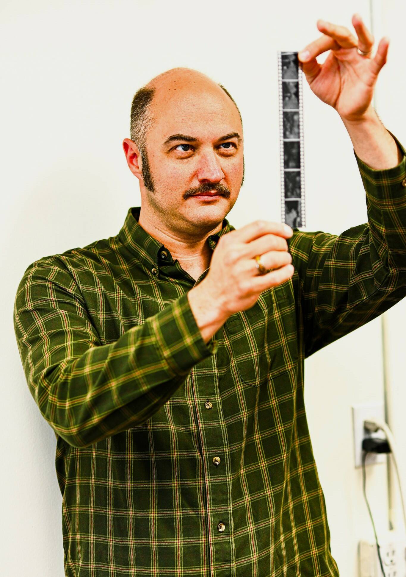 James Edens looks at 35mm film he had just developed. (Photo by By Jonathon Dawe/ Wrangell Sentinel)