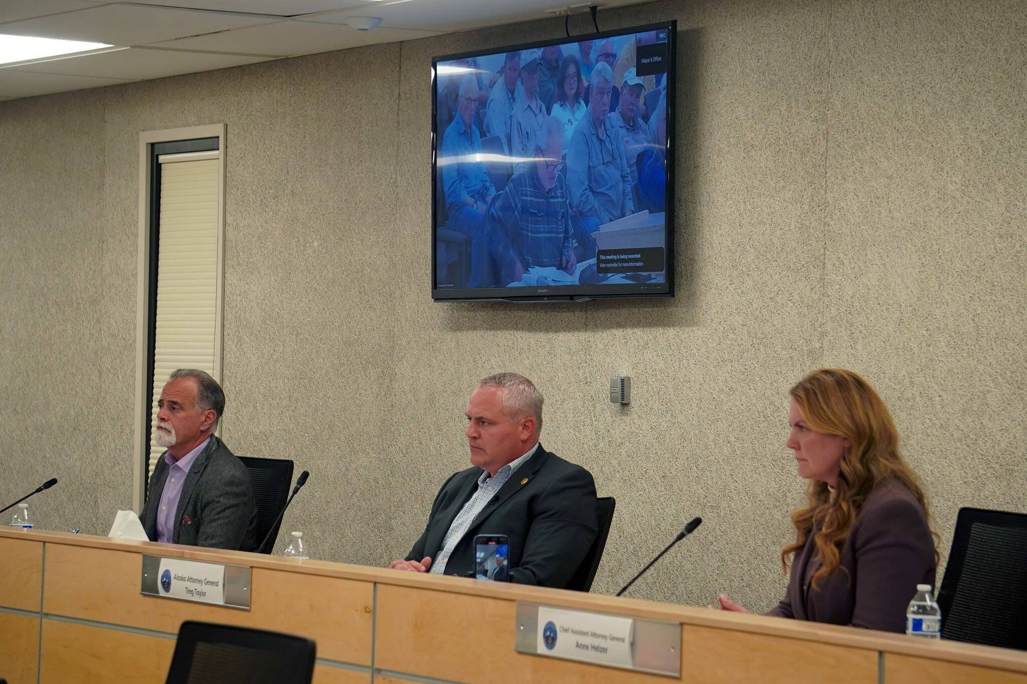 Kenai Peninsula Borough Mayor Peter Micciche, Alaska Attorney General Treg Taylor and Chief Assistant Attorney General Anne Helzer listen to testimony during a town hall on the Alaska grand jury process in the Betty J. Glick Assembly Chambers in Soldotna, Alaska, on Monday, Aug. 18, 2025. (Jake Dye/Peninsula Clarion)