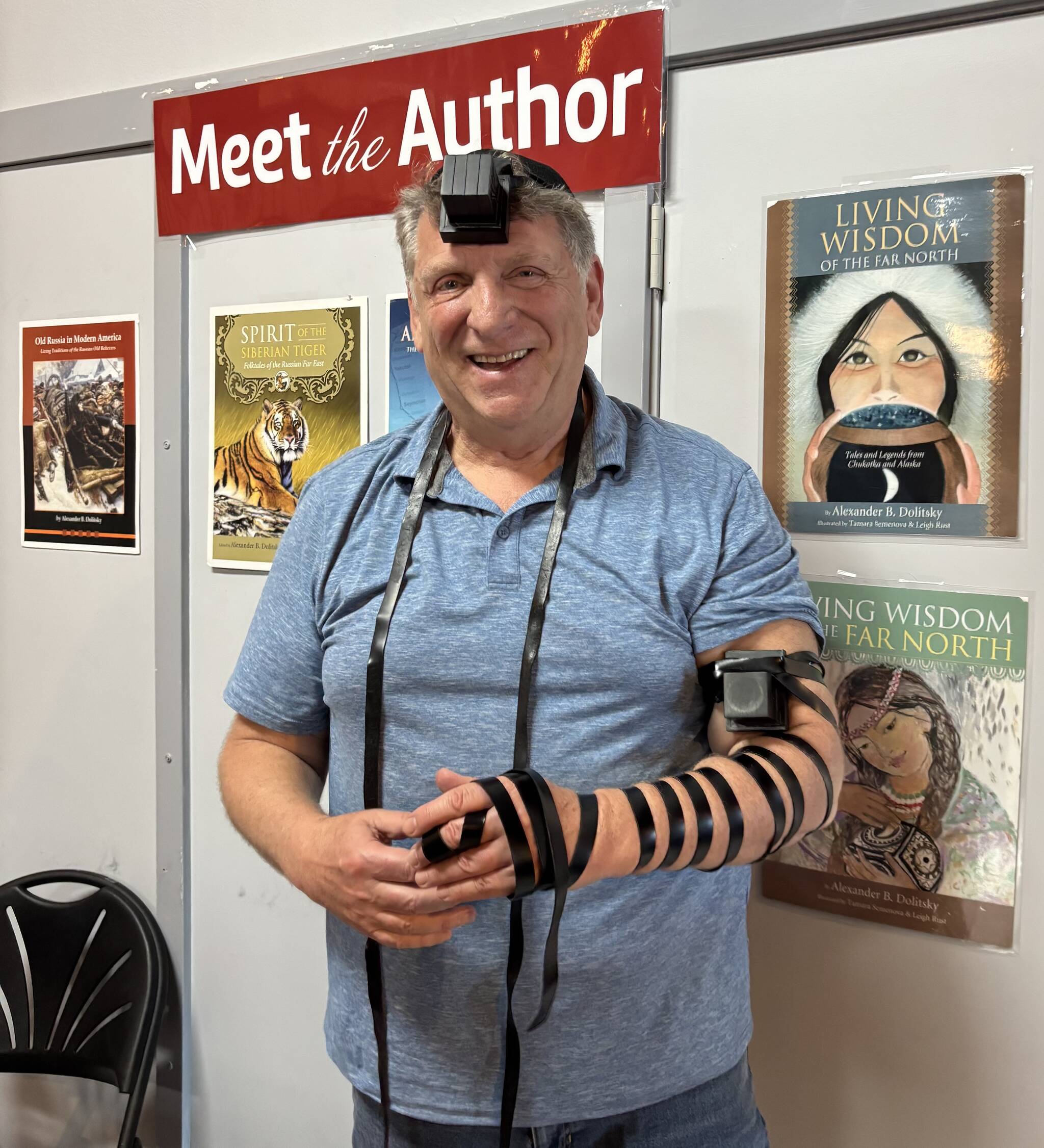 Photo provided by Alexander Dolitsky
Alexander Dolitsky participates in a traditional Jewish blessing, in which two leather boxes (tefillins) are secured around a person’s head and arm, at Hearthside Books in the Merchant Wharf Mall in downtown Juneau, August 2025.