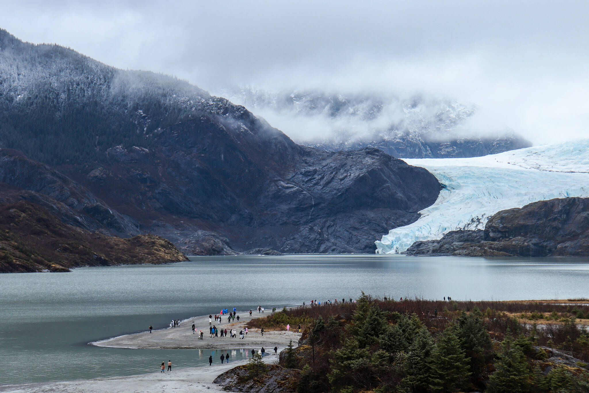 A view of visitors exploring the Mendenhall Glacier Recreation Area taken from the visitor center on Monday, April 14, 2025. (Jasz Garrett / Juneau Empire)