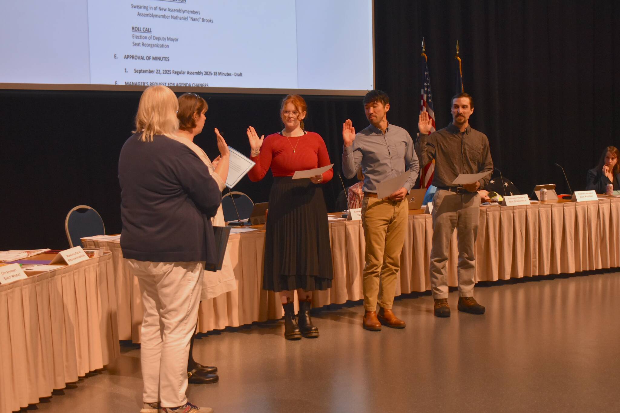 Left to right: Juneau Mayor Beth Weldon stands as Municipal Attorney Emily Wright swears in Assembly member Ella Adkison, Greg Smith and Nano Brooks at the Assembly meeting on Monday, Oct. 27. (Mari Kanagy/Juneau Empire)