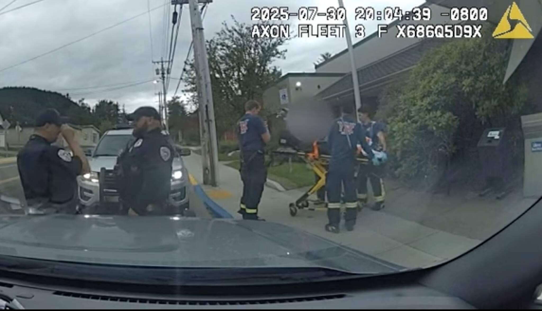 Former Juneau police officer Brandon LeBlanc stands second from the left as paramedics secure Christopher Williams Jr. to a stretcher following his arrest by LeBlanc. (Juneau Police Department screenshot)