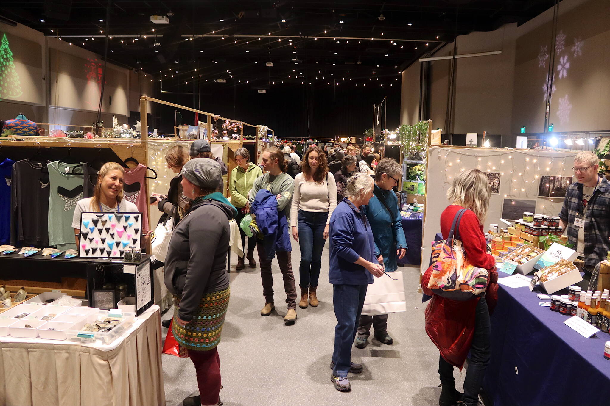 Shoppers and vendors mingle along rows of booths in the mall ballroom at Centennial Hall during the Juneau Public Market last year, which returns this year starting Friday, Nov. 28. (Mark Sabbatini / Juneau Empire file photo)