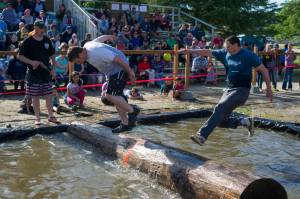 Jessie Ross, right, loses his balance against Ryan Friend in the log rolling contest at the 27th Annual Gold Rush Days Competition at Savikko Park on Sunday, June 18, 2017. (Michael Penn | Juneau Empire File)