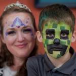 Jessica Snyder, of Sunny Days Body Art, poses with her son, Crispin, during the Block Party at the Juneau Arts & Culture Center on Friday, June 15, 2018. (Michael Penn | Juneau Empire)