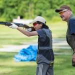 Coach Mark Kappler watches as Mackenzie Lam practices her trap shooting at the Juneau Gun Club on Thursday. (Michael Penn | Juneau Empire)