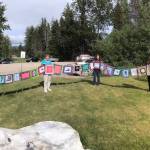 From left to right: Meadow Brook, Kate Boesser, Denise Pratschner, Sandy Schroth, Rita Savage, Chris Gabriele, Annie Mackovjak, Becky King and Ellie Sharman hold up all of thequiltlets together, running about 85 feet long. Photo courtesy of Ellie Sharman.