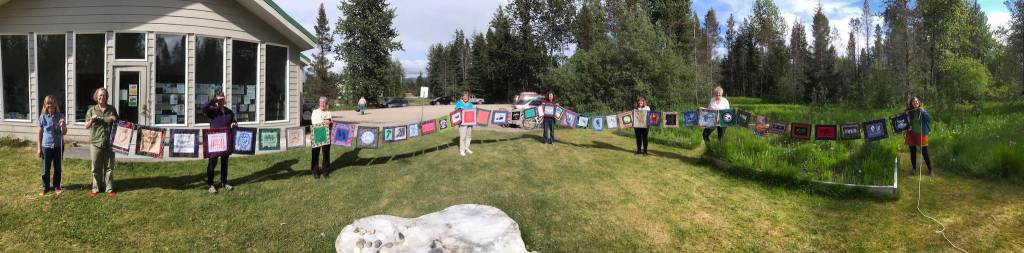 From left to right: Meadow Brook, Kate Boesser, Denise Pratschner, Sandy Schroth, Rita Savage, Chris Gabriele, Annie Mackovjak, Becky King and Ellie Sharman hold up all of thequiltlets together, running about 85 feet long. Photo courtesy of Ellie Sharman.