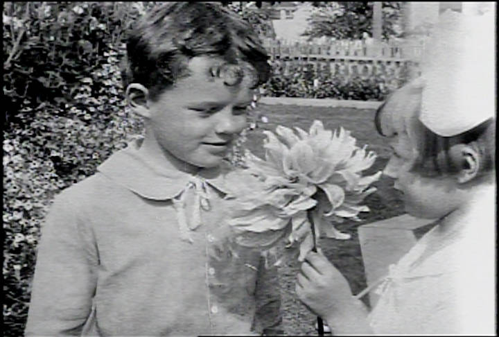 A still from A Day in Skagway, the Burton Holmes travelogue produced for Paramount Pictures in 1918. This scene is of a boy and girl (Kenneth Blanchard and Evelyn Curtin) sharing a large dahlia in one of Skagways beautiful gardens. Photo courtesy of Human Studies Film Archives, Smithsonian Institution; the American Film Institute and the National Film and Sound Archives, Australia.
