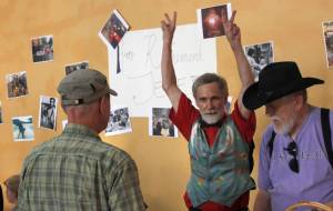 Jeff Brown, center, raises peace signs in the air as his name is announced at the Jeff Brown Appreciation Party at the Juneau Arts and Culture Center on Friday, July 6, 2018. The party was a celebration of Browns 40-year career at KTOO. (Alex McCarthy | Juneau Empire)