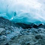 Light glows through ice cave walls as a stream flows through. (Gabe Donohoe)