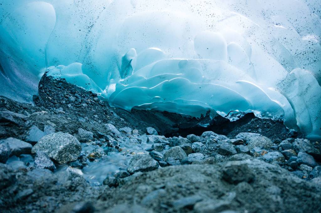 Light glows through ice cave walls as a stream flows through. (Gabe Donohoe)