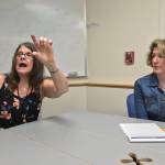 Southeast Alaska Independent Living employees Pam Muelleriguy and Sherri von Wolfe talk about closed captioning devices recently installed at Glacier Cinemas at SAIL office Friday morning. (Gregory Philson | Juneau Empire)