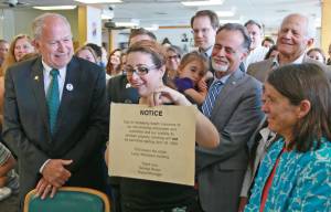In a photo provided by the office of the governor, Gov. Bill Walker signs Senate Bill 63, a statewide public smoking ban, on Tuesday, July 17, 2018 at the Lucky Wishbone restaurant in Anchorage. Standing at right is Sen. Peter Micciche, R-Soldotna, the legislative sponsor of the bill. On Walkers lap is Stella Micciche, one of Micciches daughters. Also visible, from right to left behind Walker are Dr. Jay Butler, Alaskas chief medical officer; Rep. Geran Tarr, D-Anchorage; Rep. Jason Grenn, I-Anchorage; Micciche; Rep. Chris Birch, R-Anchorage; and the smile of Emily Nenon of the American Cancer Society. (Courtesy photo)
