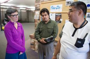 Kim Champney, a disability advocate, meets with Melvin Starr, center, and Luis Hernandez to hang posters at the Mendenhall Mall advertising this weekends Disability Pride Celebration. The celebration is Saturday, July 21, from 3 to 5 p.m. at Marine Park. (Michael Penn | Juneau Empire)