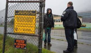 In this August 2017 file photo, Juneau Police Department officers serve notices of eviction to homeless Juneauites living on Mental Health Trust Authority land in downtown Juneau. A legislative committee has suggested the Trusts CEO, Mike Abbott, might be guilty of a crime for leaking an under-development audit. (Michael Penn | Juneau Empire file)
