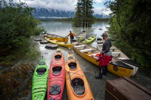 Nic Sevic, left, and Elliot Sofhauser, of Above and Beyond Alaska gather canoes and kayaks from storage at Mendenhall Lake on Thursday, July 19, 2018, after a release of water from Suicide Basin on Wednesday caused the lake to rise. (Michael Penn | Juneau Empire)
