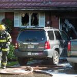 A Capital City Fire/Rescue fireman walks away after fighting a house fire at 8460 Kimberly Street on Friday, July 20, 2018. (Michael Penn | Juneau Empire)