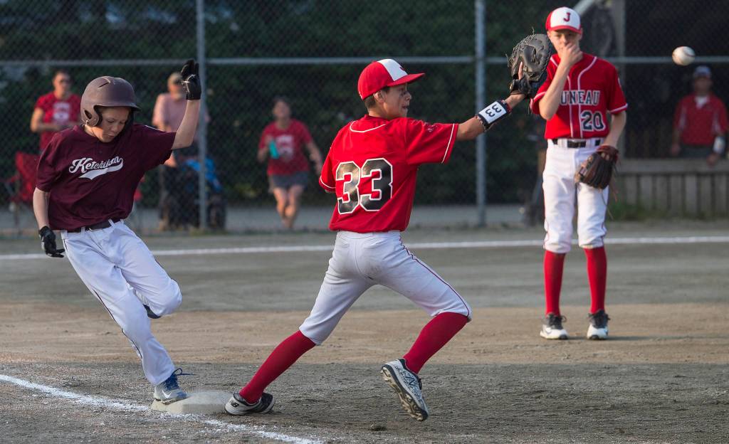Ketchikans Jack Zink, left, beats the throw to Gastineau Channels first baseman Kaeden Quinto in the eighth inning of the Alaska Major Baseball District 2 Championship Game at Miller Field on Tuesday. (Michael Penn | Juneau Empire)