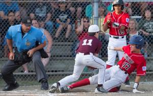 Gastineau Channels Thomas Baxter is caught trying to steal home by Ketchikans Colby Hanchey in the second inning of the Alaska Major Baseball District 2 Championship Game at Miller Field on Tuesday. (Michael Penn | Juneau Empire)