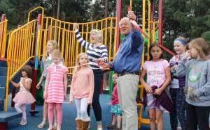 Glacier Valley Rotary President Sharon Burns and Mayor Ken Koelsch cut a ribbon on the new playground equipment at Riverside Rotary Park on Saturday, July 28, 2018. (Alex McCarthy | Juneau Empire)