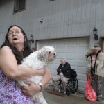 Hazel LeCount holds her pet dog, Serenity, as she waits with other residents to be let back into the Channel View Apartments on Sunday after a fire broke out in a unit on the fifth floor.
