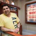 Raj Bathija, owner of Celebrity Jewelers, stands next to one of his signs explaining the added fees charged by cruise ship promotion companies aimed at steering cruise ship passengers to preferred stores.