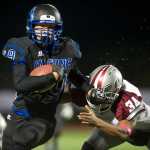 Thunder Mountain's running back Shannon Olmstead pushes off Ketchikan's Trevor Ortiz during their game in Juneau on Friday.