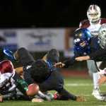 Thunder Mountain's Mahina Toutaiolepo dives to recover after Q'on Bear-Clark is forced to fumble by Ketchikan's Cameron Harris, left, and Nate Fousel during their game in Juneau on Friday.